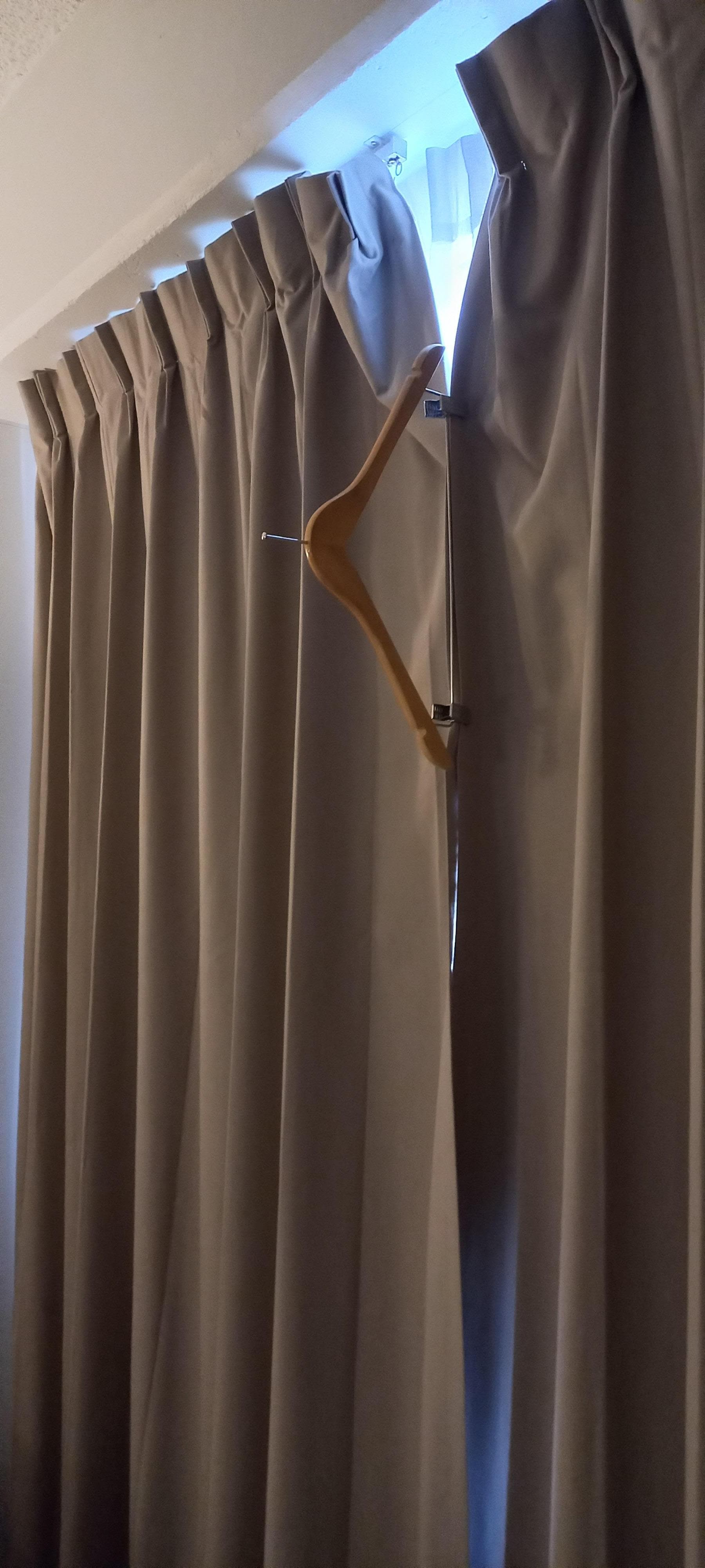 Used coat hanger to close curtains.note gap at top of photo