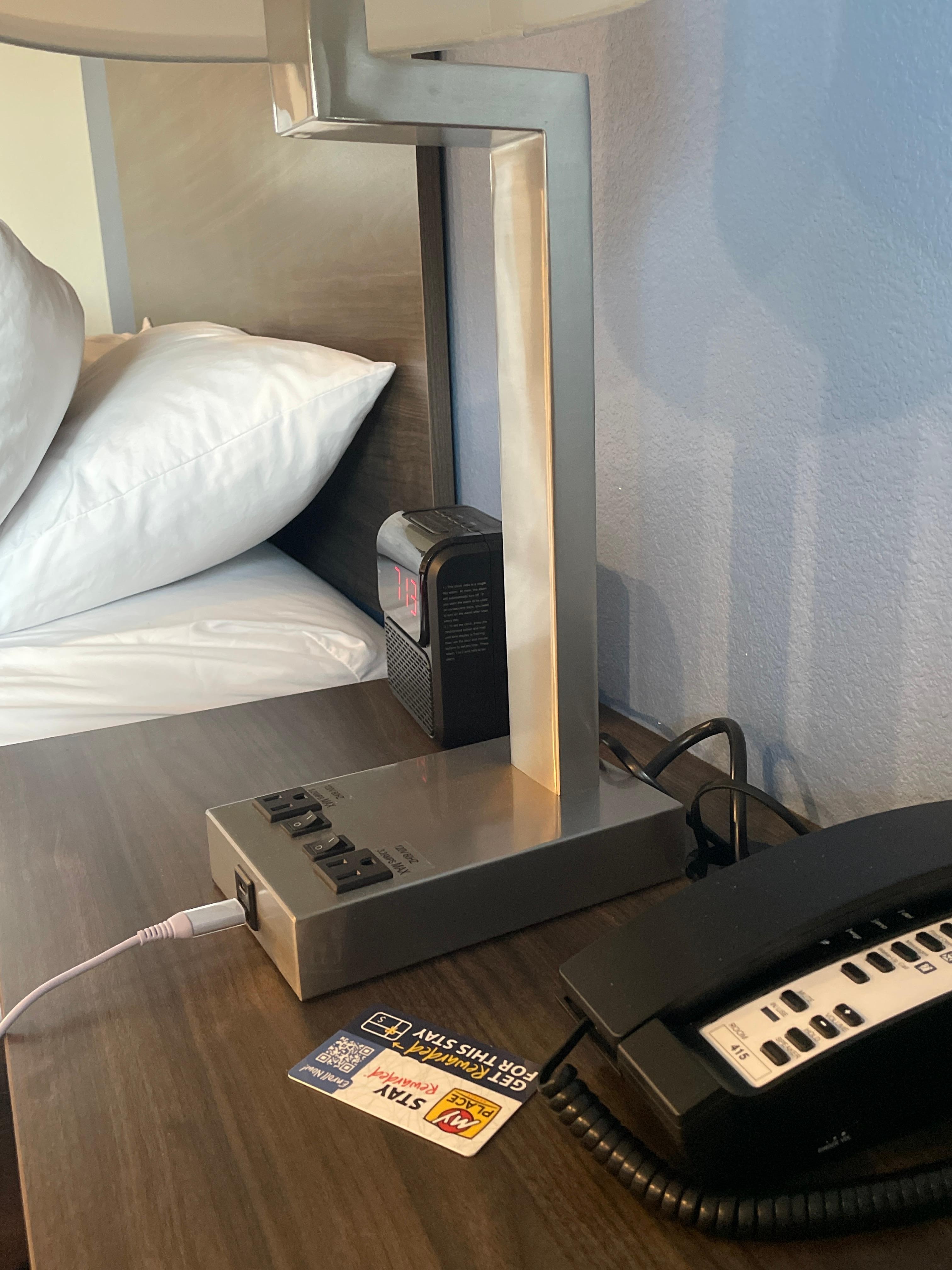 USB ports, outlets, lamp, phone, clock between two beds. 