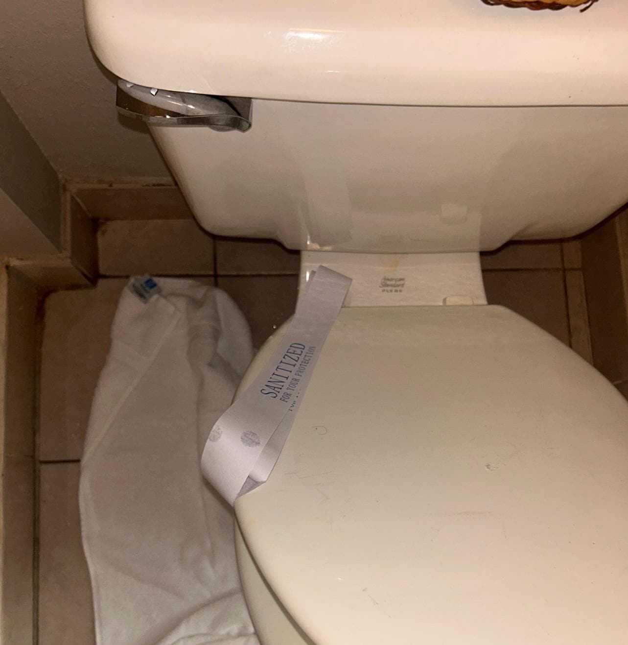 Dirty toilet with sanitized seal  on it 