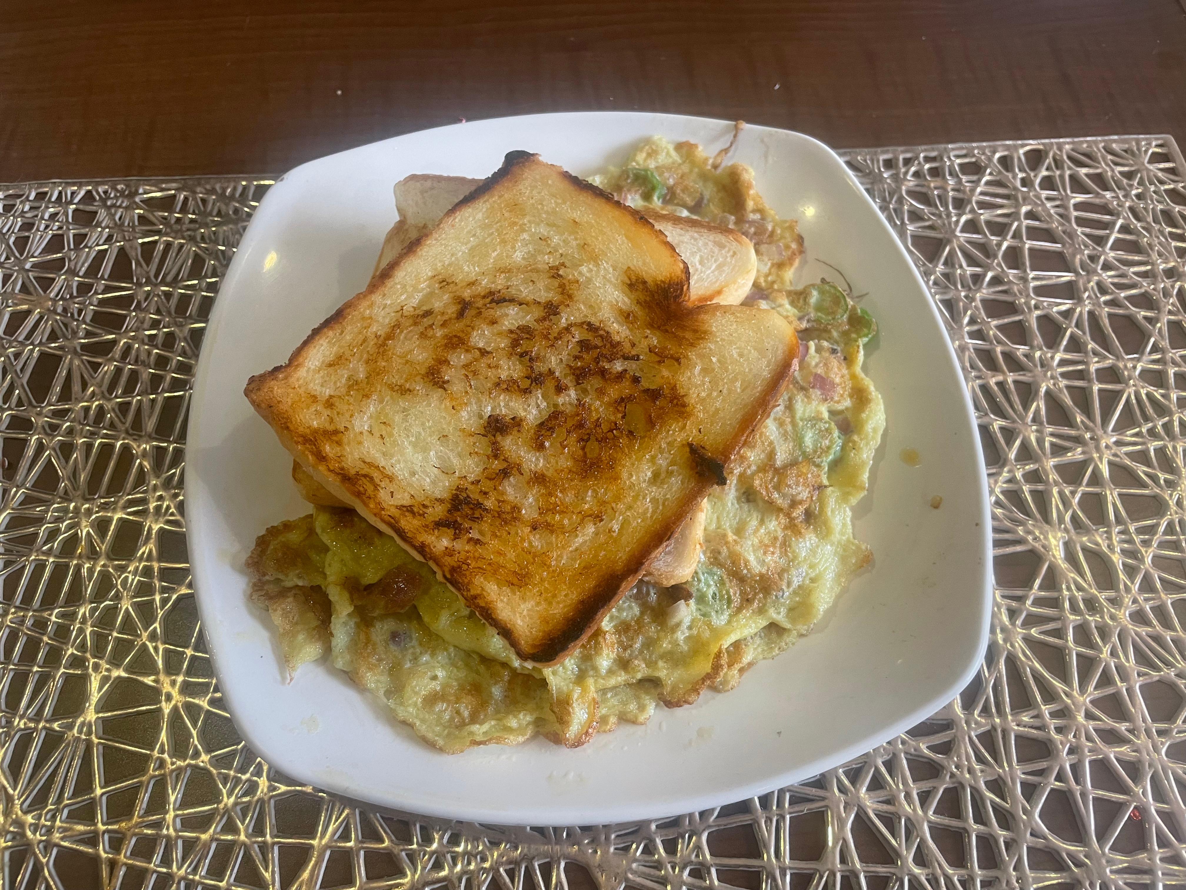 Bread omelette soaked in oil & served without cutlery 