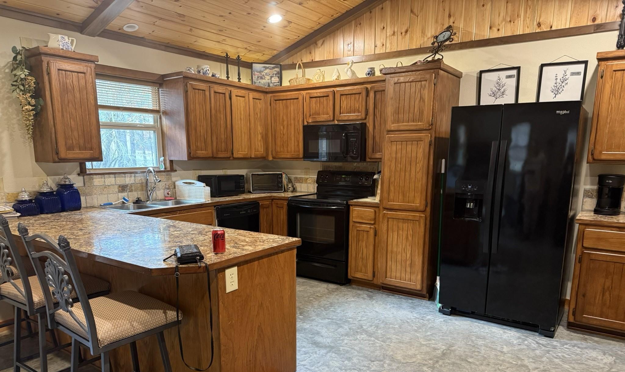Kitchen with side-by-side fridge with ice, electric range, microwave, dishwasher, toaster oven, electric griddle, drip coffee maker, slow cooker, blender, and deep fryer.