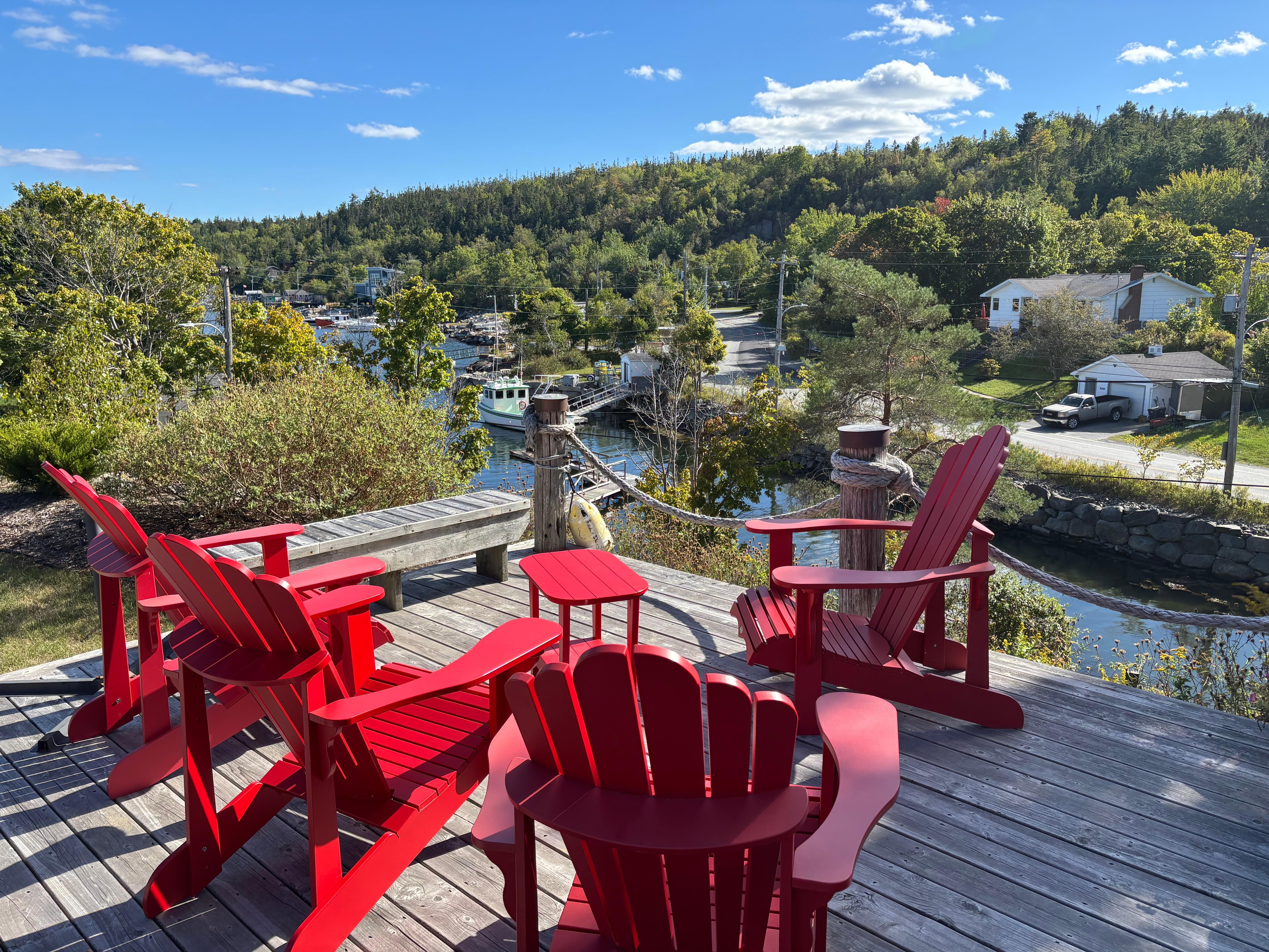 An outdoor deck, perfect for morning coffee, overlooking the water including a lobster shack & boat