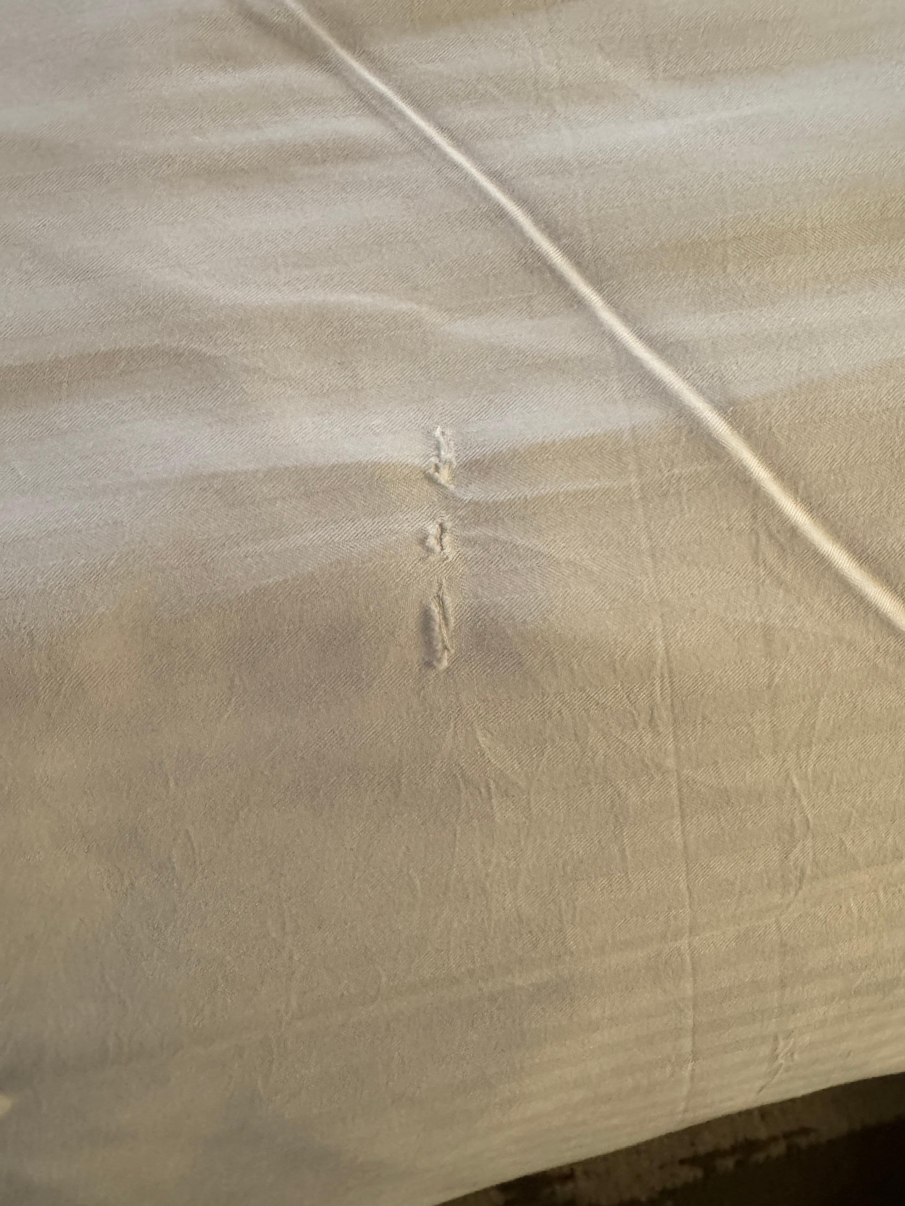 Torn sheets across bottom bed