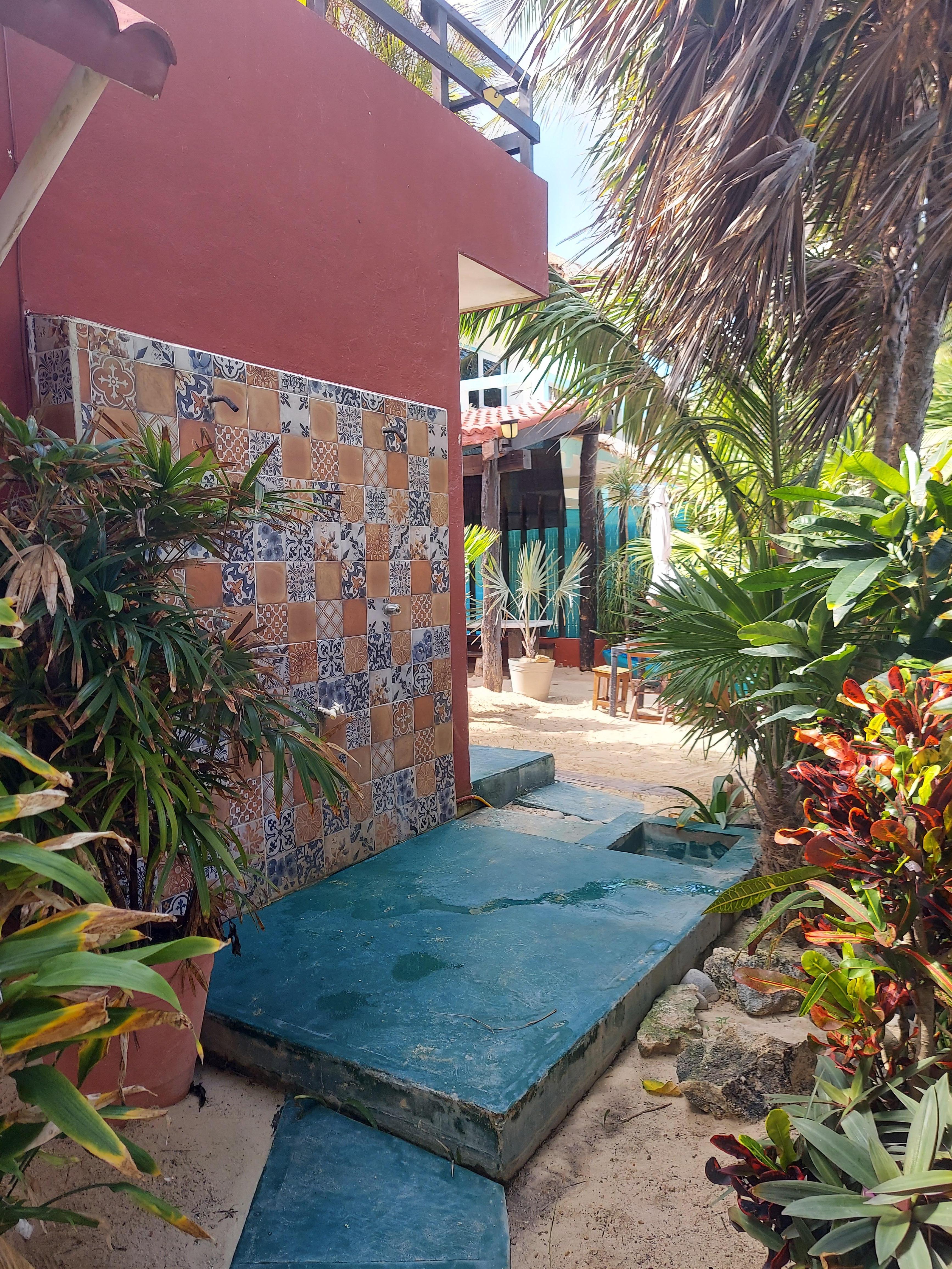 Downstairs outdoor shower off courtyard, which has seating and a kitchen