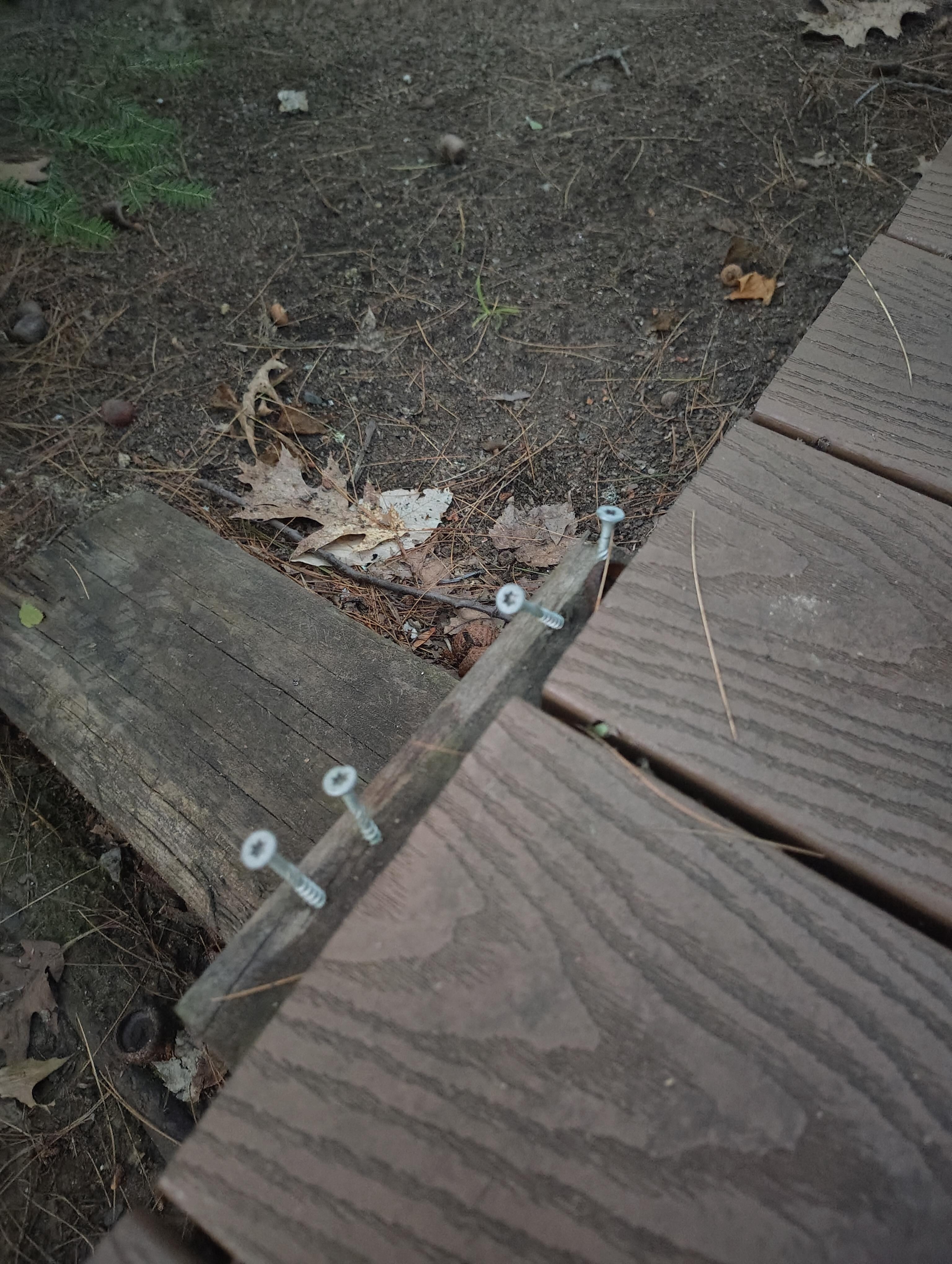 Nails sticking up from wood down by water where the chairs, table and fire pit are.