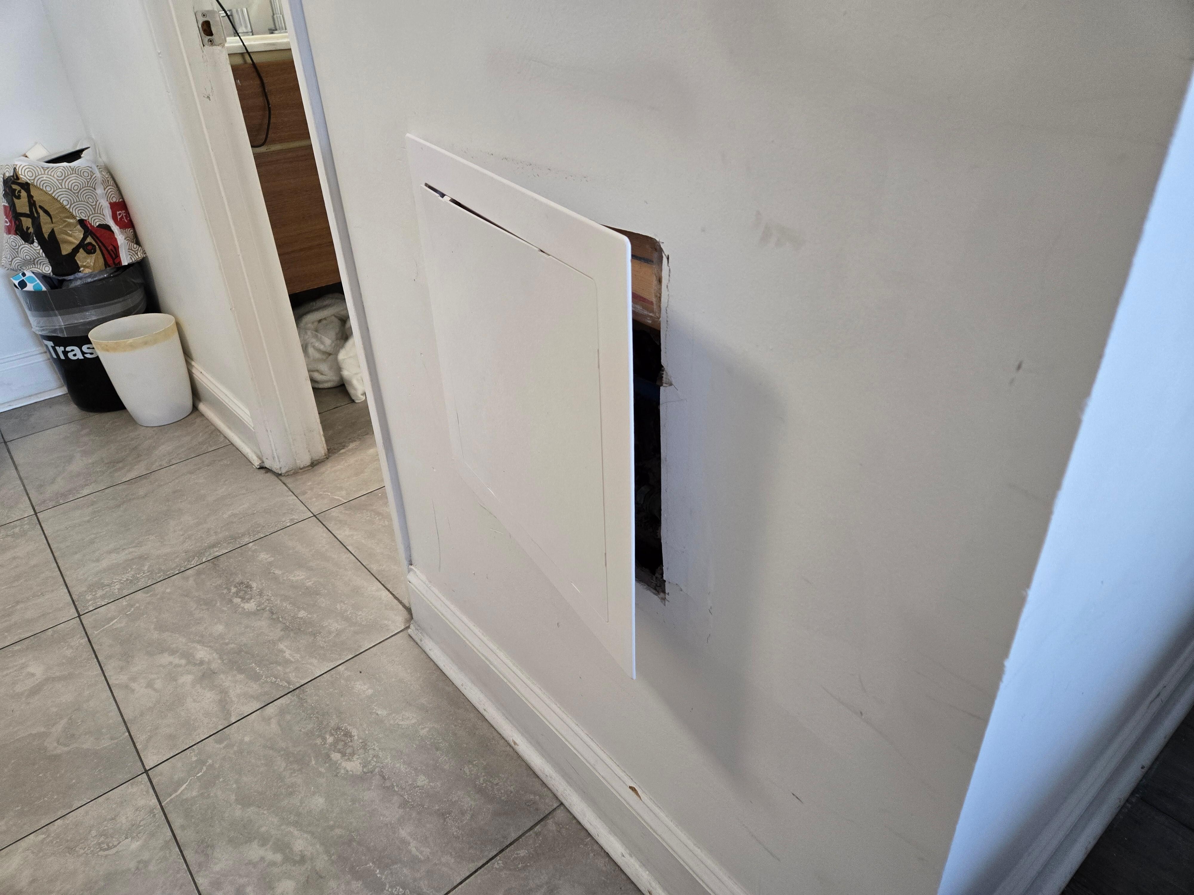 The cover for the bathroom water valves fell twice when the door closed.   