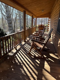 Lovely front porch with plenty of seating. There is a table with chairs on the other side of the porch.