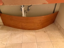 Thin piece of MDF bent to cover pipe in bathroom