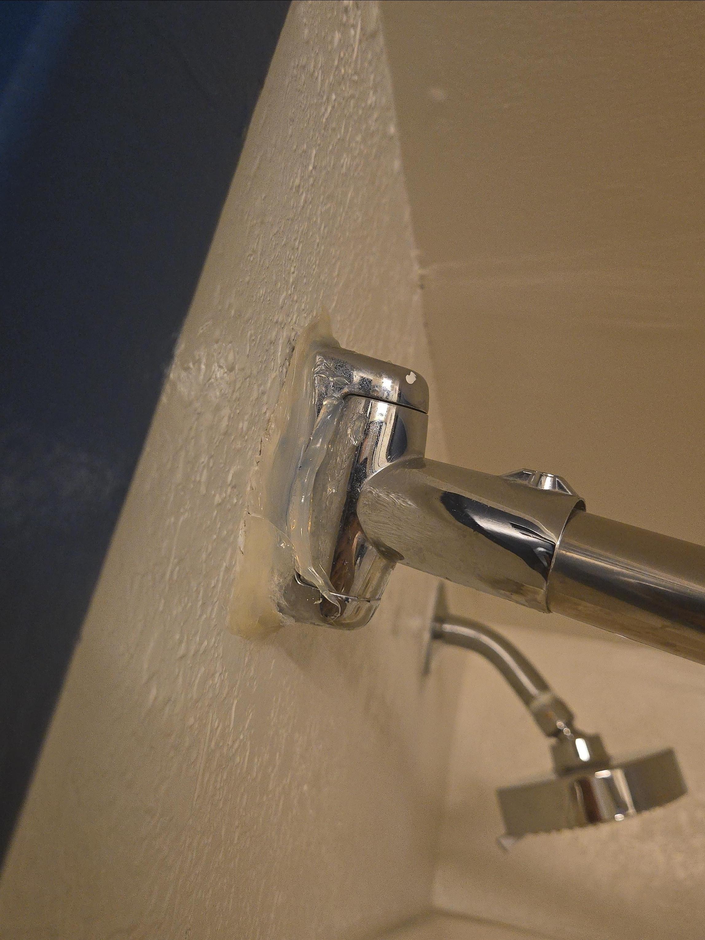 The shower curtain rod is glued to the wall