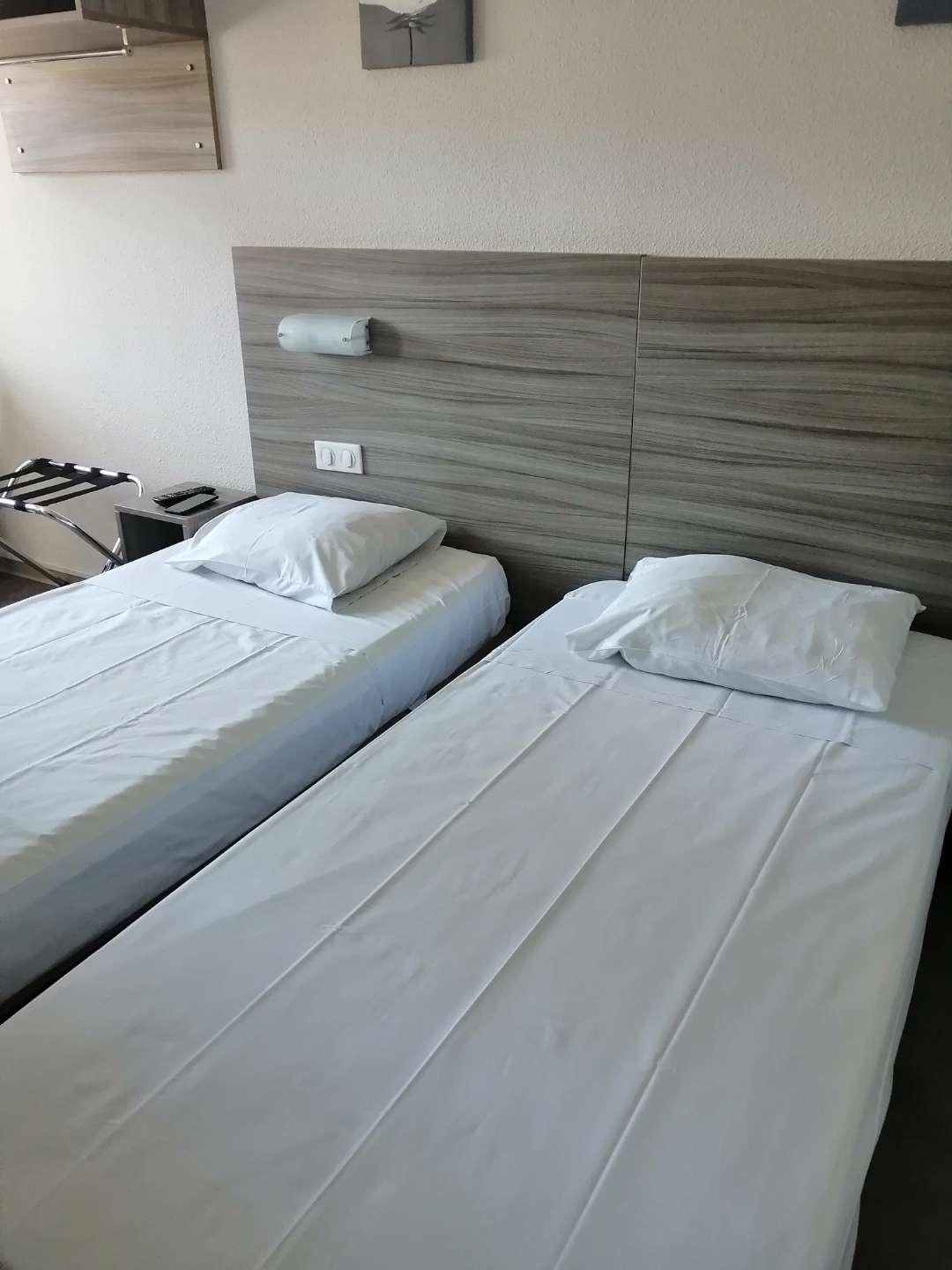 2 twin beds with bedside tables, storage for your clothes, a desk, multiple power outlets and a small bathroom. The room also has Air conditioning.