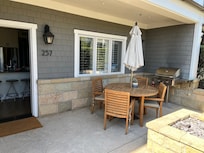 Front porch includes table and chairs, BBQ, and fire pitp