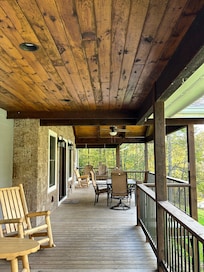 Huge front porch with outdoor dining table & chairs and a porch swing