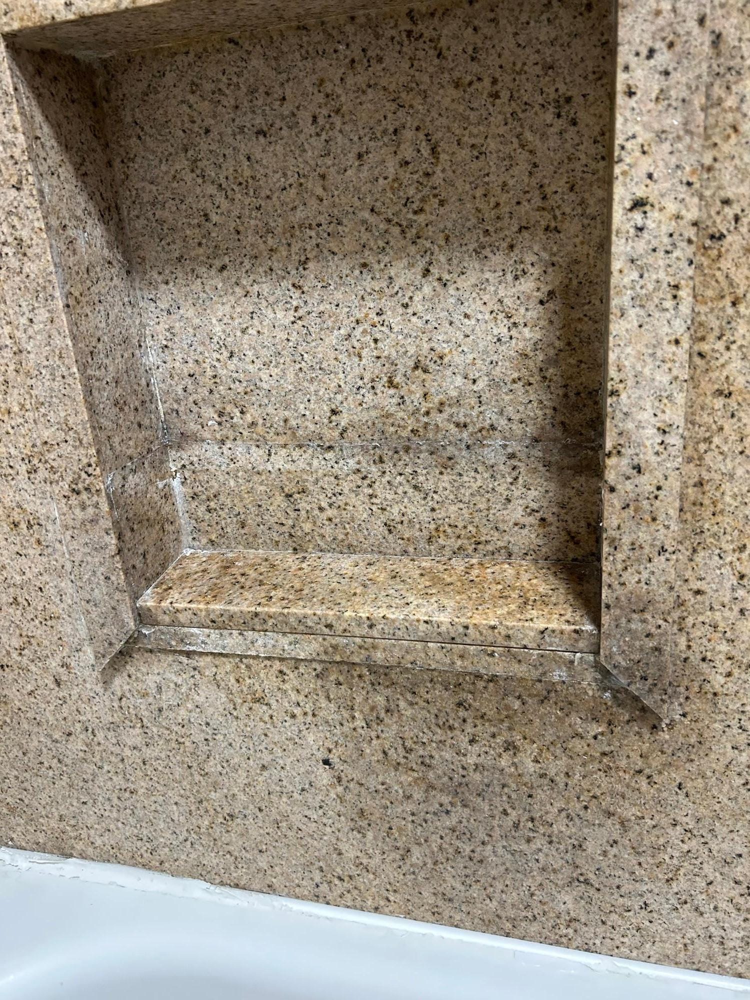 The shelve in the bathroom shower that is broken.