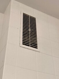 Grille de ventilation dans la douche pleine de toile d’araignées