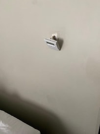 Thermostat hanging off the wall