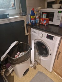 Clothes in the machine and old rubbish in the bin