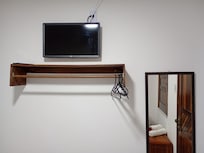 Televisão, espelho e cabideiro