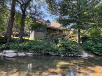 Standing in the middle of the river directly in front of the house.