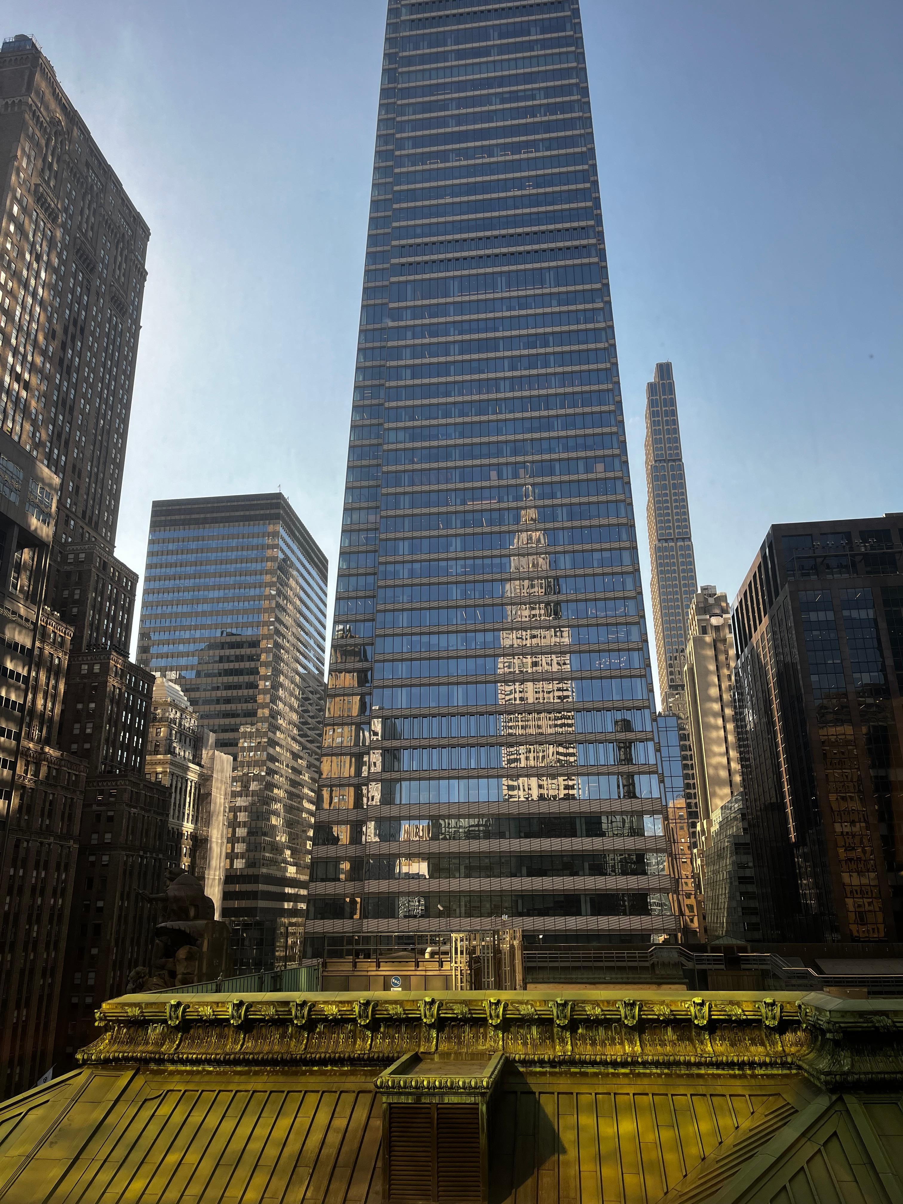 Amazing view from window with reflection of Chrysler building in skyscraper; Grand Central Station below