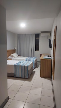 Quarto duplo com vista para a rua, com frigobar; falta lugar para pendurar toalha no quarto