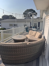 Back deck with table-top fire-pit facing yard with fire-pit and grill