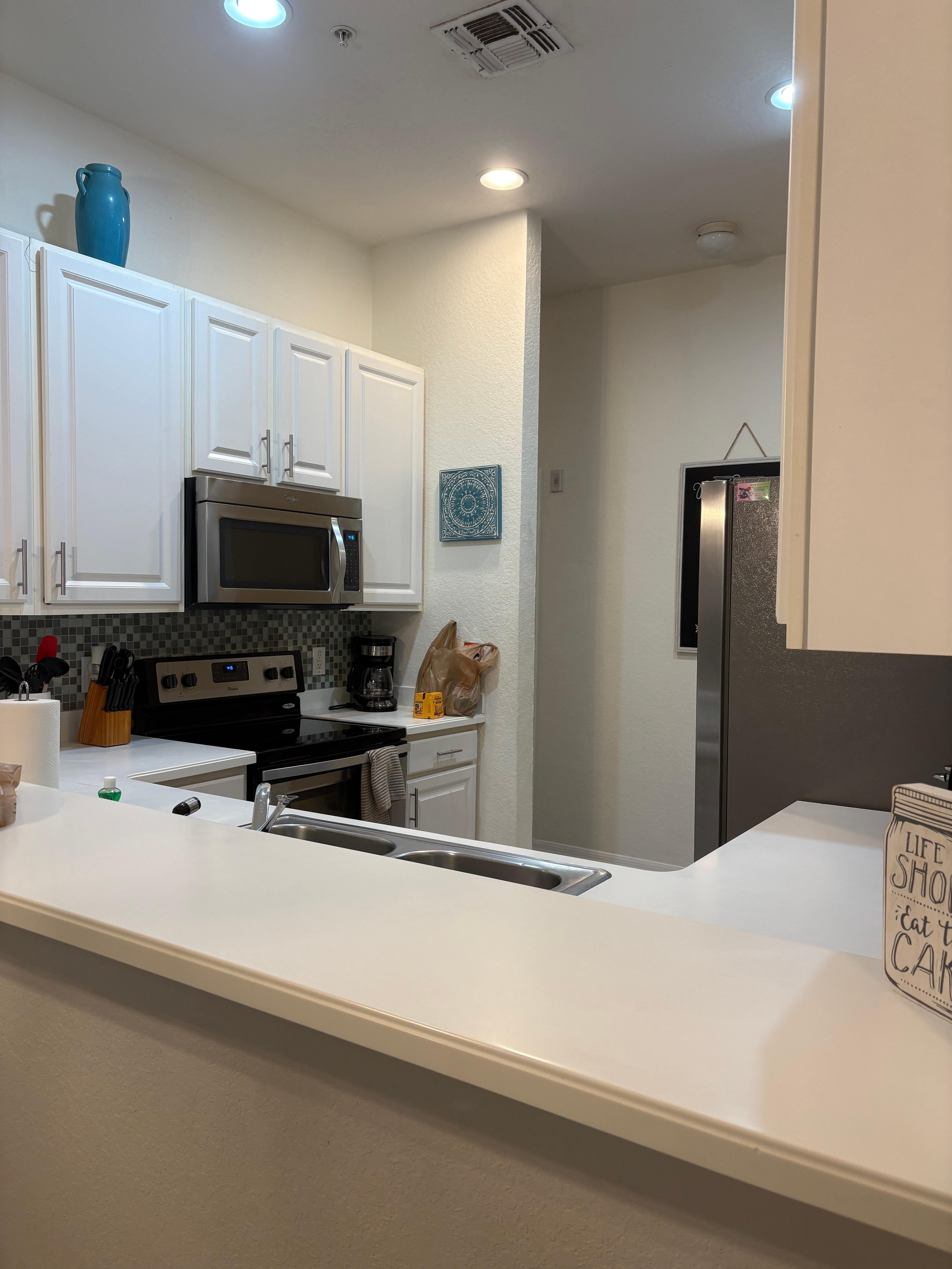 Kitchen is well-lit, clean, and loaded with what you need to cook and clean up.