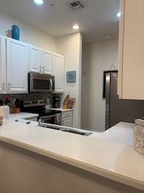 Kitchen is well-lit, clean, and loaded with what you need to cook and clean up.