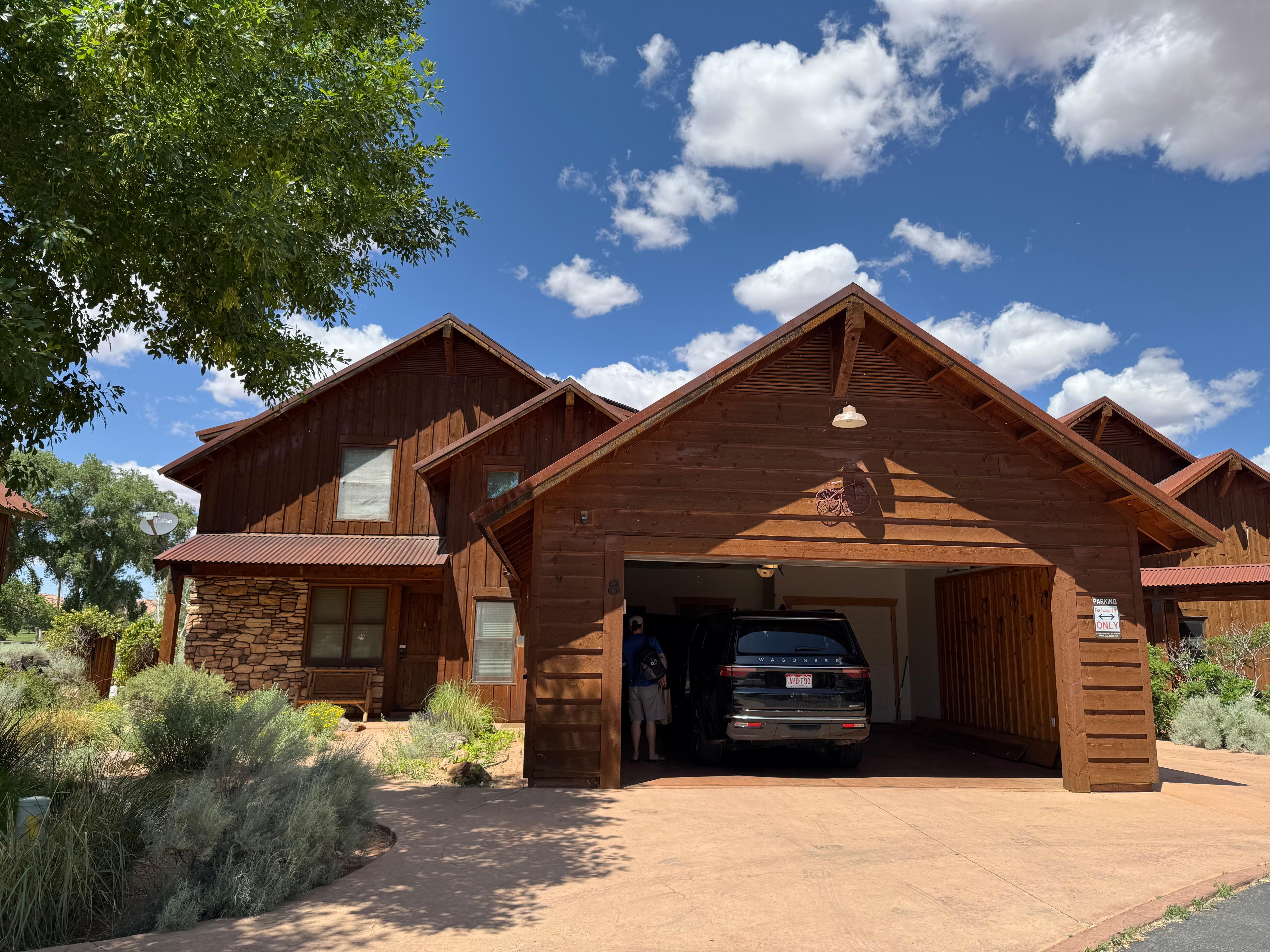 Front of property with large garage and nice bench in front porch 
