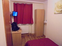 TV, desk & wardrobe, with window to the enclosed small yard.