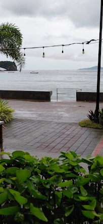 Sitting in the open air resort restaurant looking at the Sea.