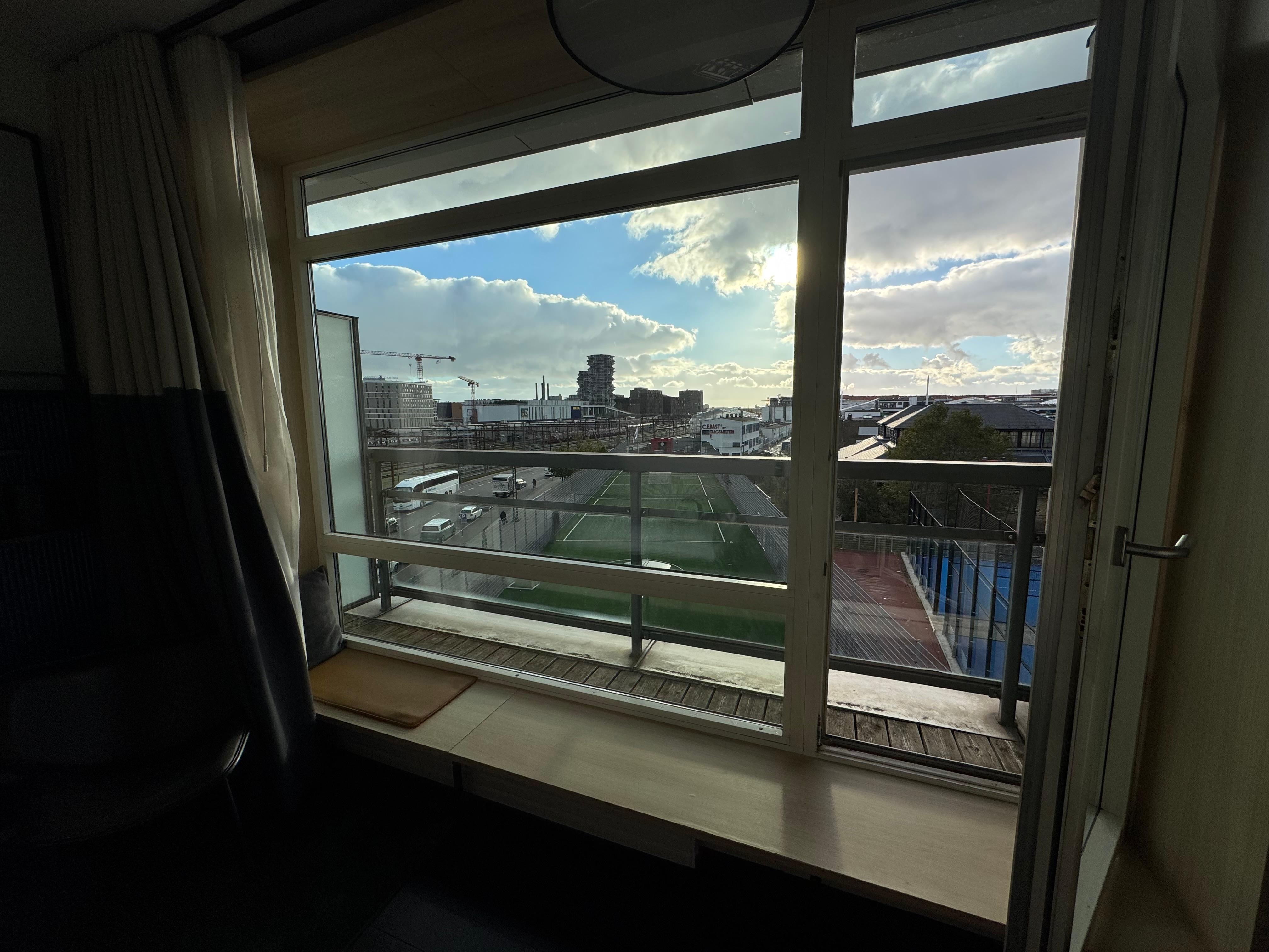 Third floor view with a small balcony and a window sill with seating