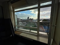 Third floor view with a small balcony and a window sill with seating