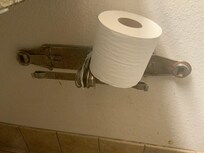 Rusty toilet paper holder, but at least they provided a roll..