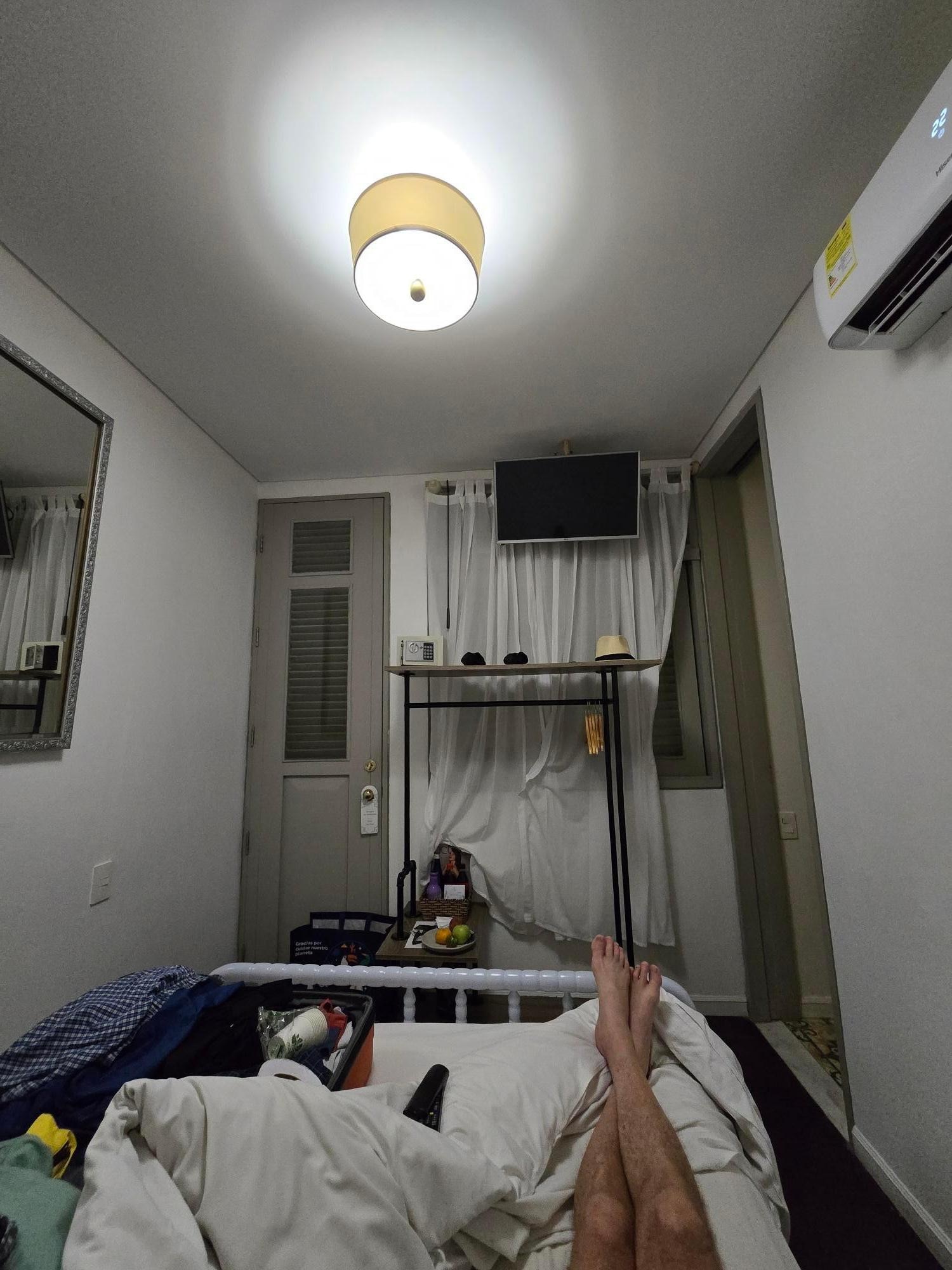 VERY small room. Luggage on bed, because couldn't put it on floor and actually open it. That thing behind the sheers is as close to a window as you get. No option to open to let light in. 