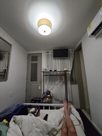 VERY small room. Luggage on bed, because couldn't put it on floor and actually open it. That thing behind the sheers is as close to a window as you get. No option to open to let light in.