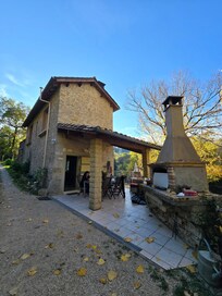 La petite maison avec une avancée couverte pour manger et un barbecue.