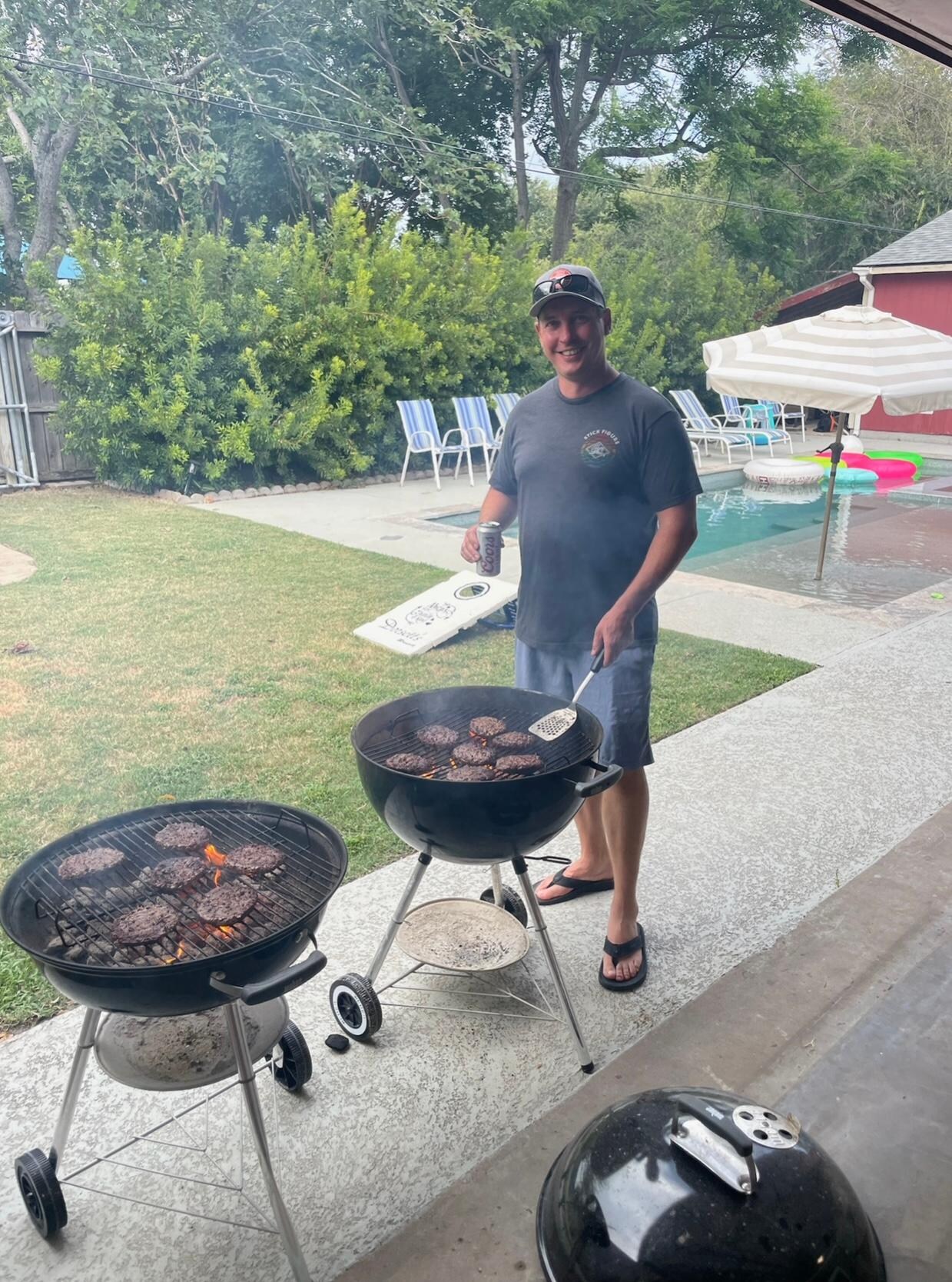 My son cooking burgers on the two webbers