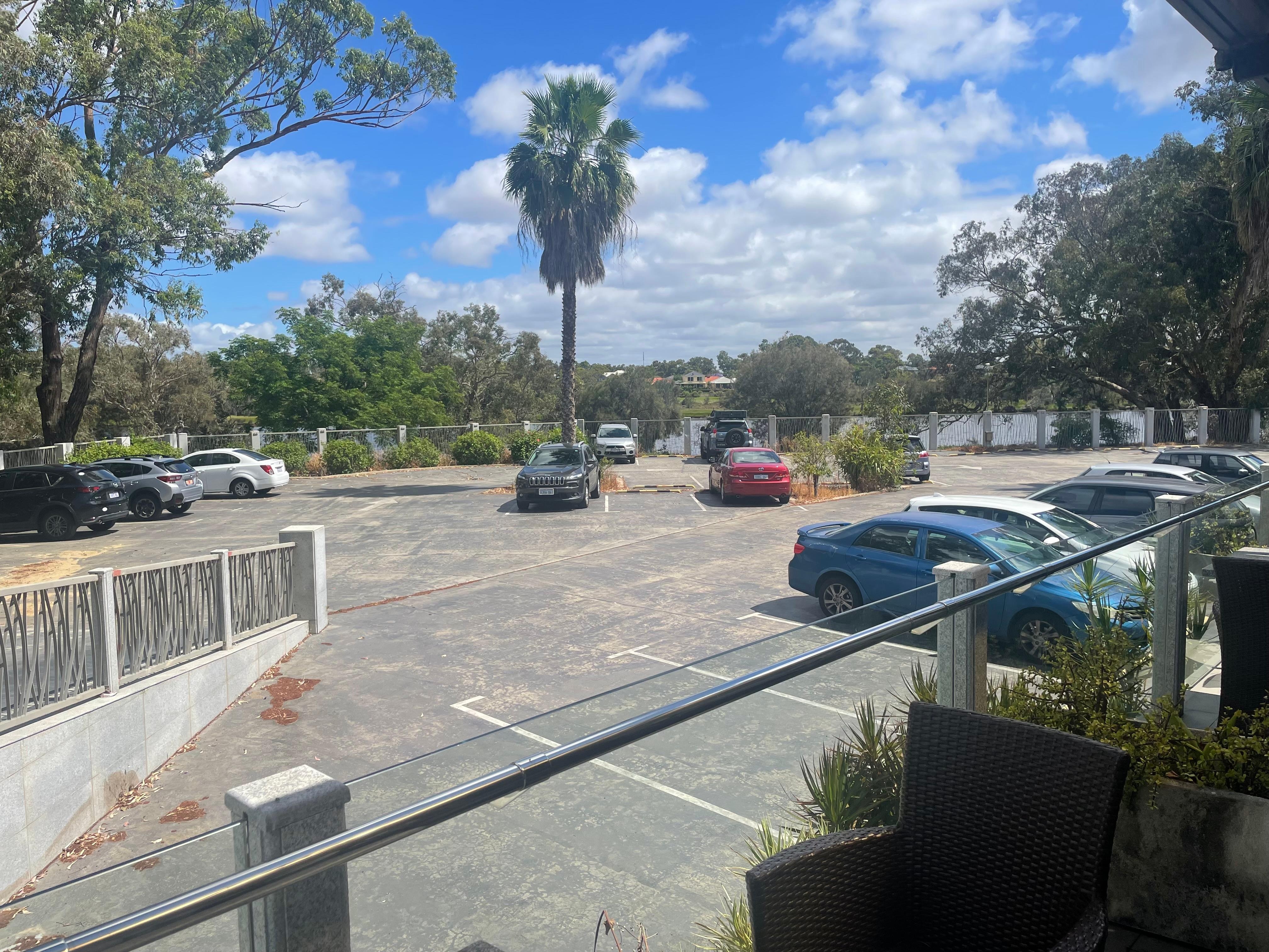 Chambre avec vue sur le parking derrière lequel il y a une rivière 