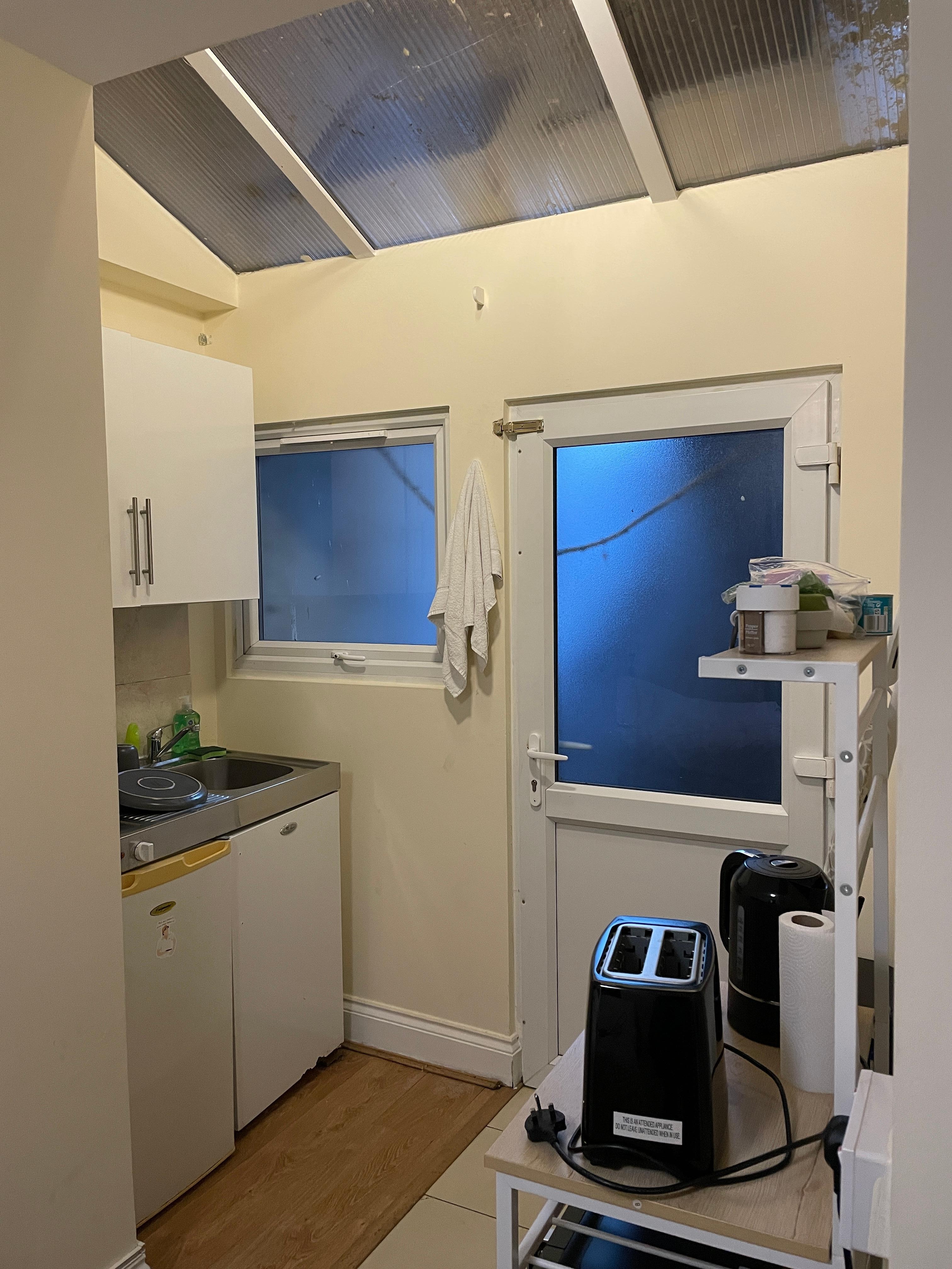 Kitchenette: verrière en plexiglas, absence de rideau et fenêtres condamnées.
