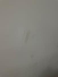 Dirt/stain on the wall close to one of the beds