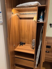 Closet space, with hairdryer and fan.