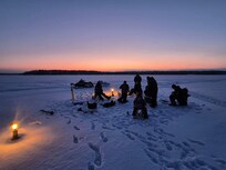 Ice fishing out in front near the cabin