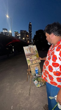 Jerrel Sustaita, Live Local Artist, making a live painting at the bat watching party- congress bridge