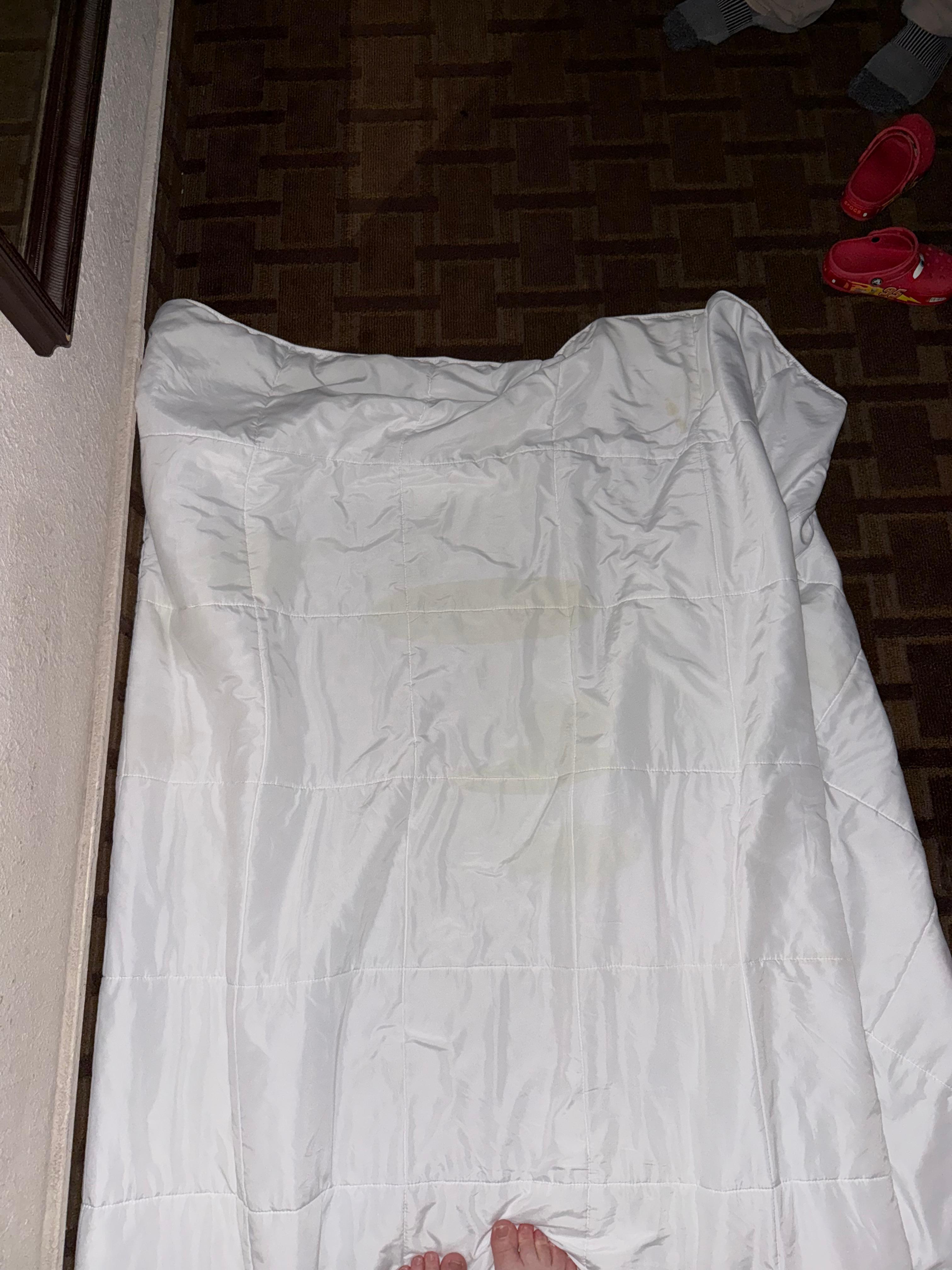 Blanket from bed with yellow pee like stains. 