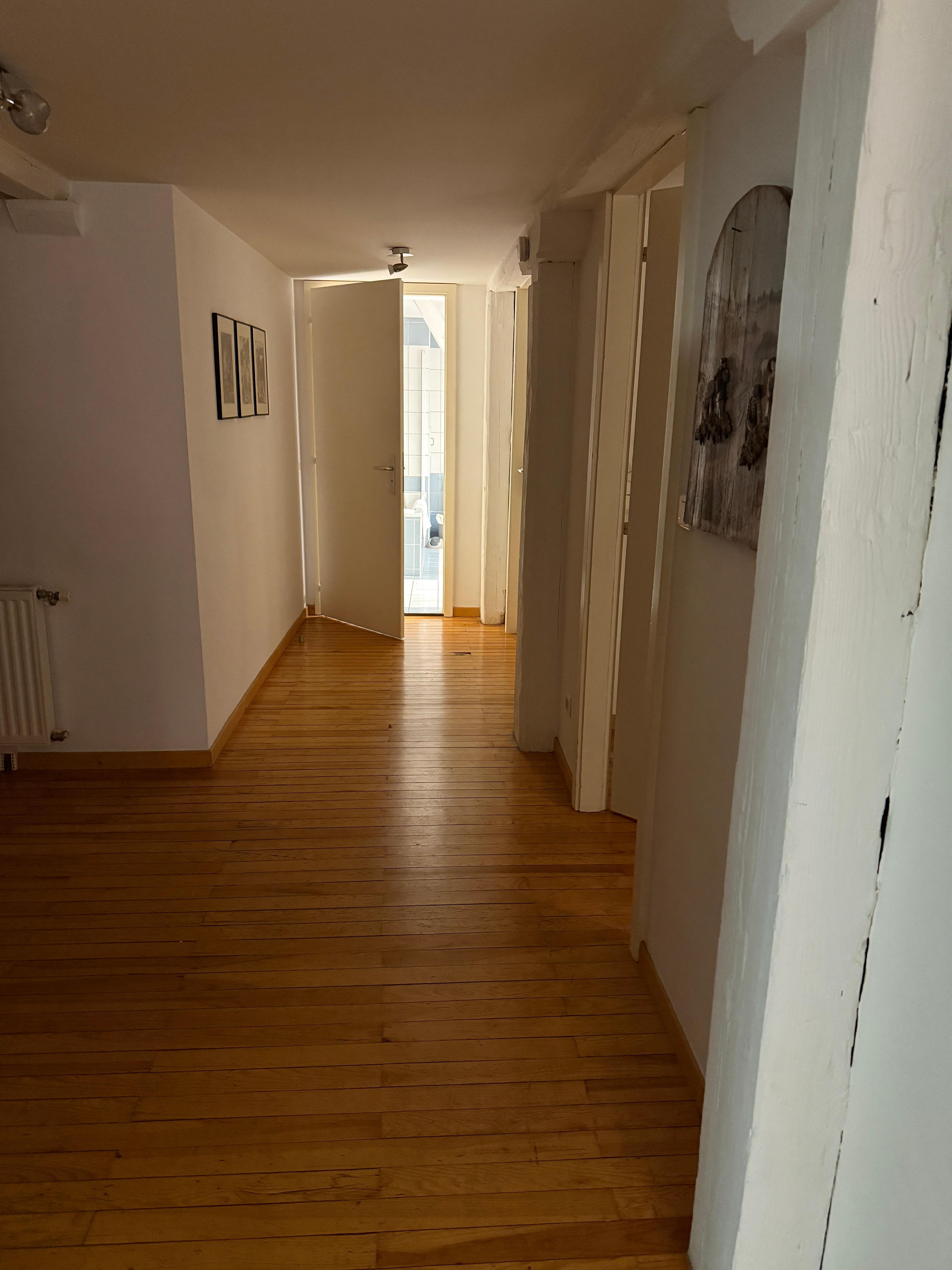 Looking down hall from kitchen to bathroom. Large bedroom next to bathroom and smaller one before that. 