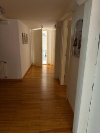 Looking down hall from kitchen to bathroom. Large bedroom next to bathroom and smaller one before that.