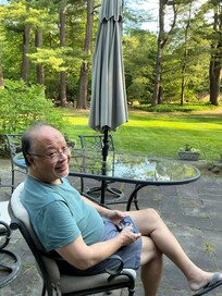 Hubby sipping a gin and tonic while grilling some food, surrounded by the lovely landscaped yard.