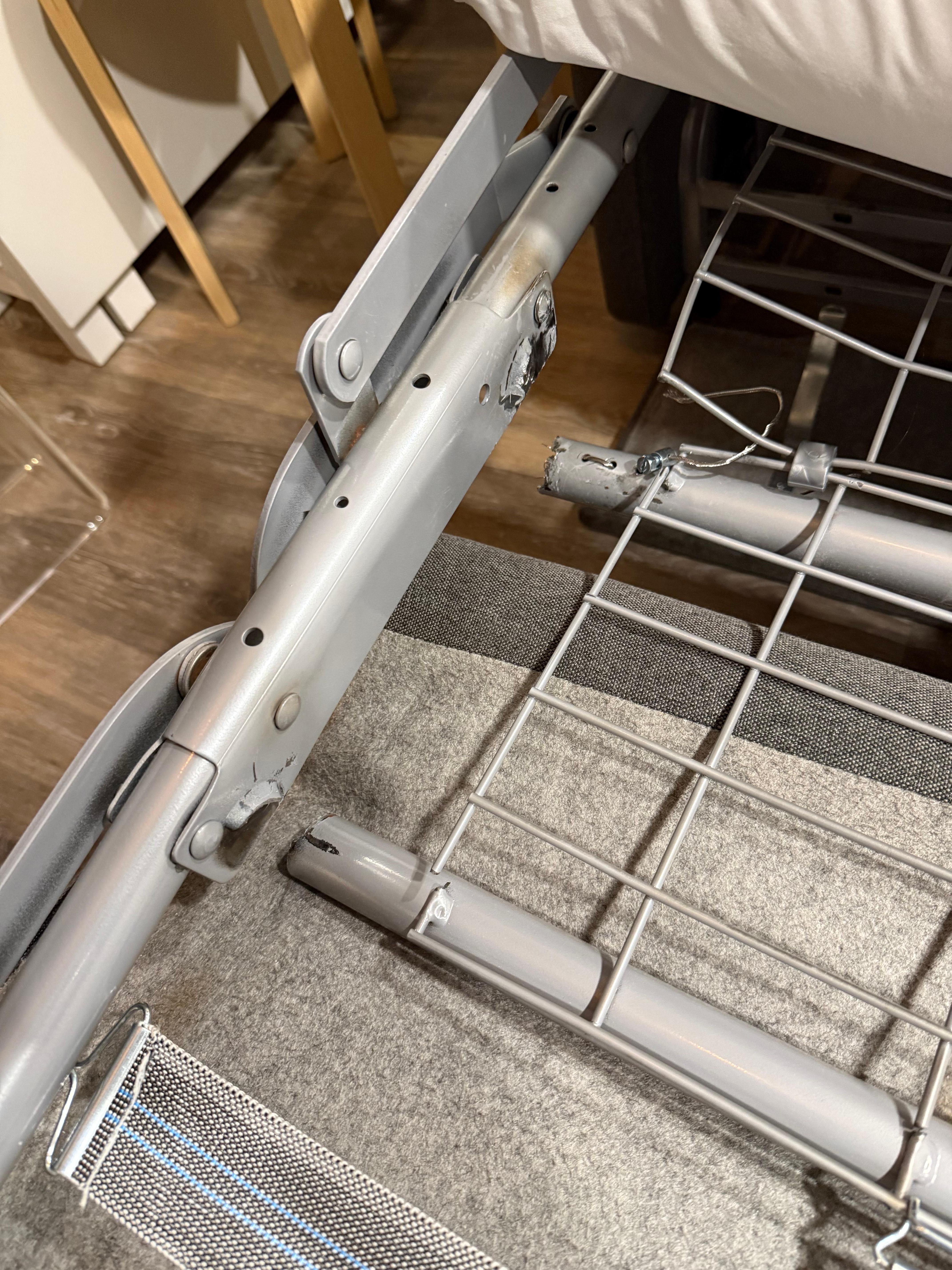 Shows two broken crossbar supports that hold up pull-out bed mattress.