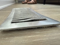 Twisted heat register that didn't fit closely to the floor.