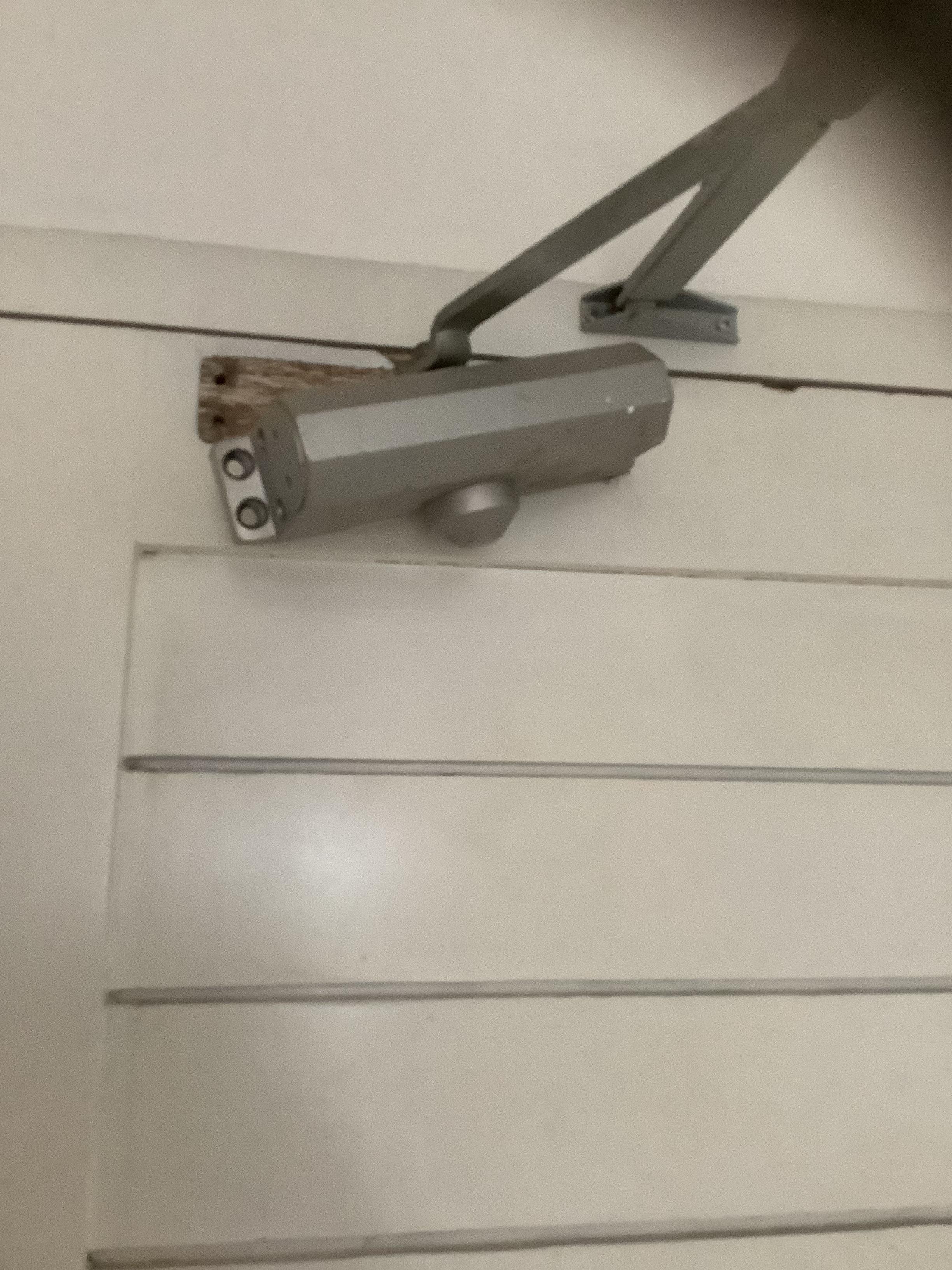 Door closer hanging off, screws missing